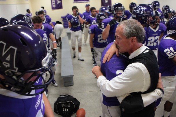 Ann Arbor Pioneer head coach Paul Test singles out a player to embrace after the team's pre-game prayer before the kickoff of it's home game against Birmingham Brother Rice on Thursday, Aug. 30. Chris Asadian | AnnArbor.com
